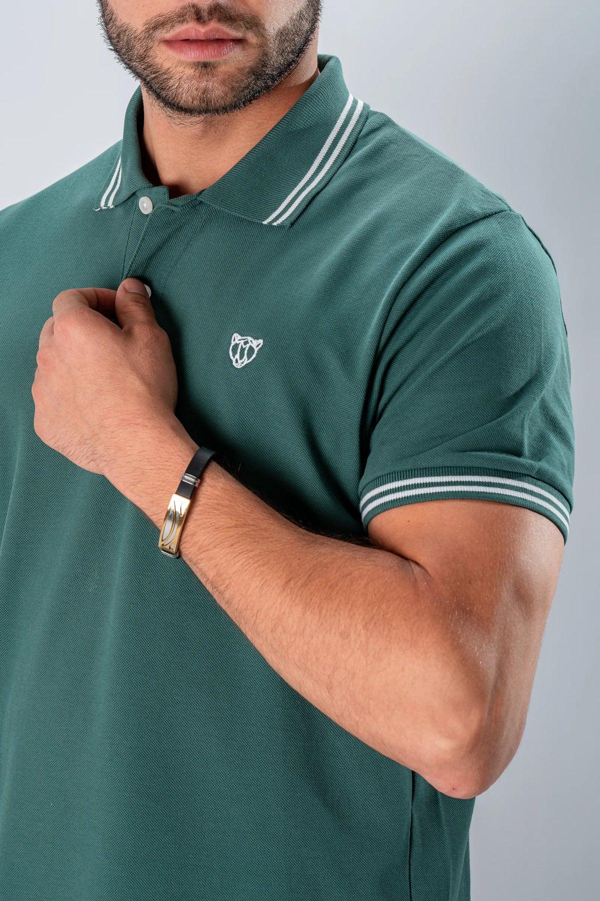 A man in a green piqué polo with a white tipped collar